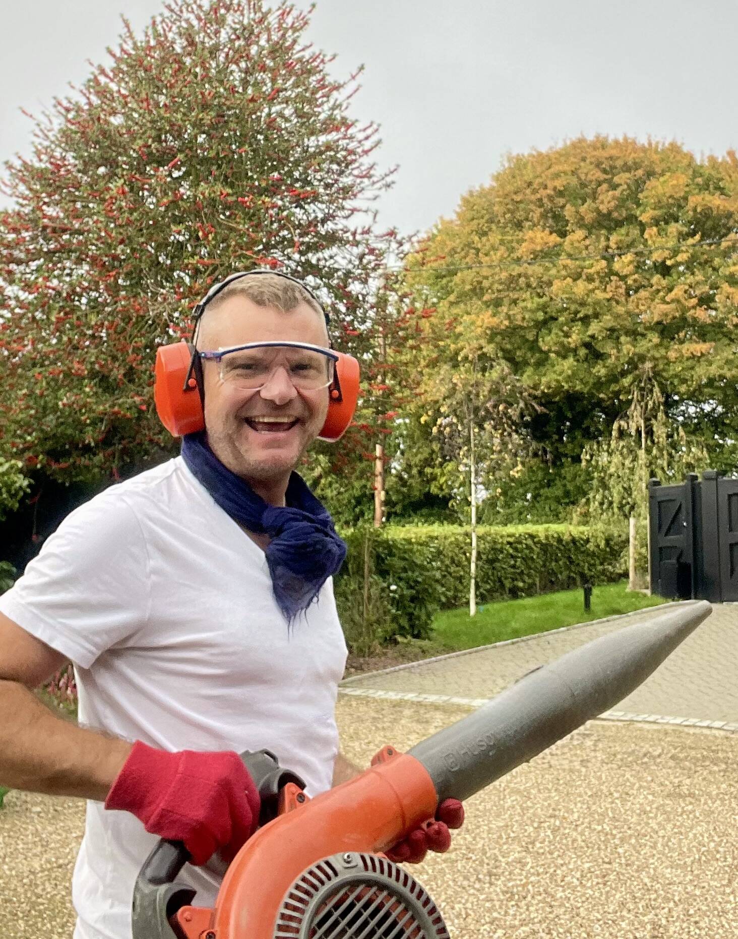 Michael working outdoors with a leaf blower and ear defenders
