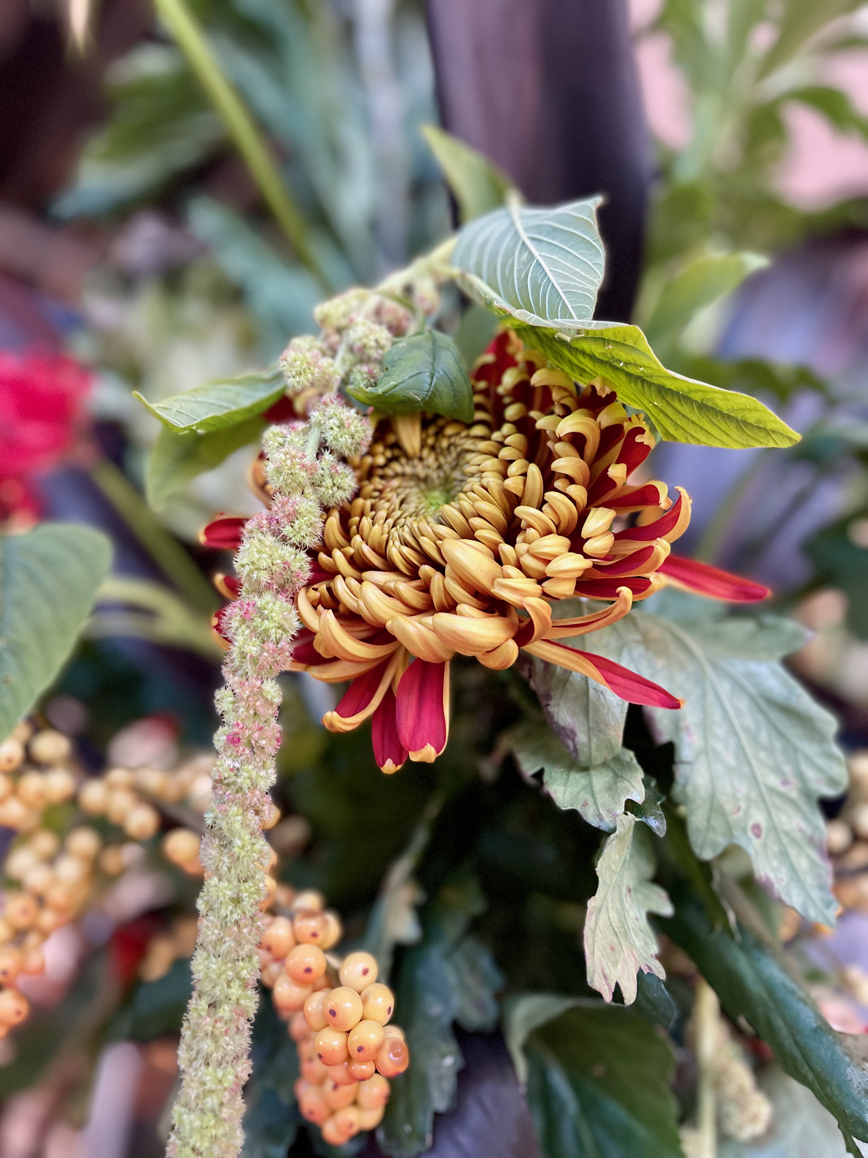 A close view of chrysanthemums, berries and foliage in the event urn arrangement
