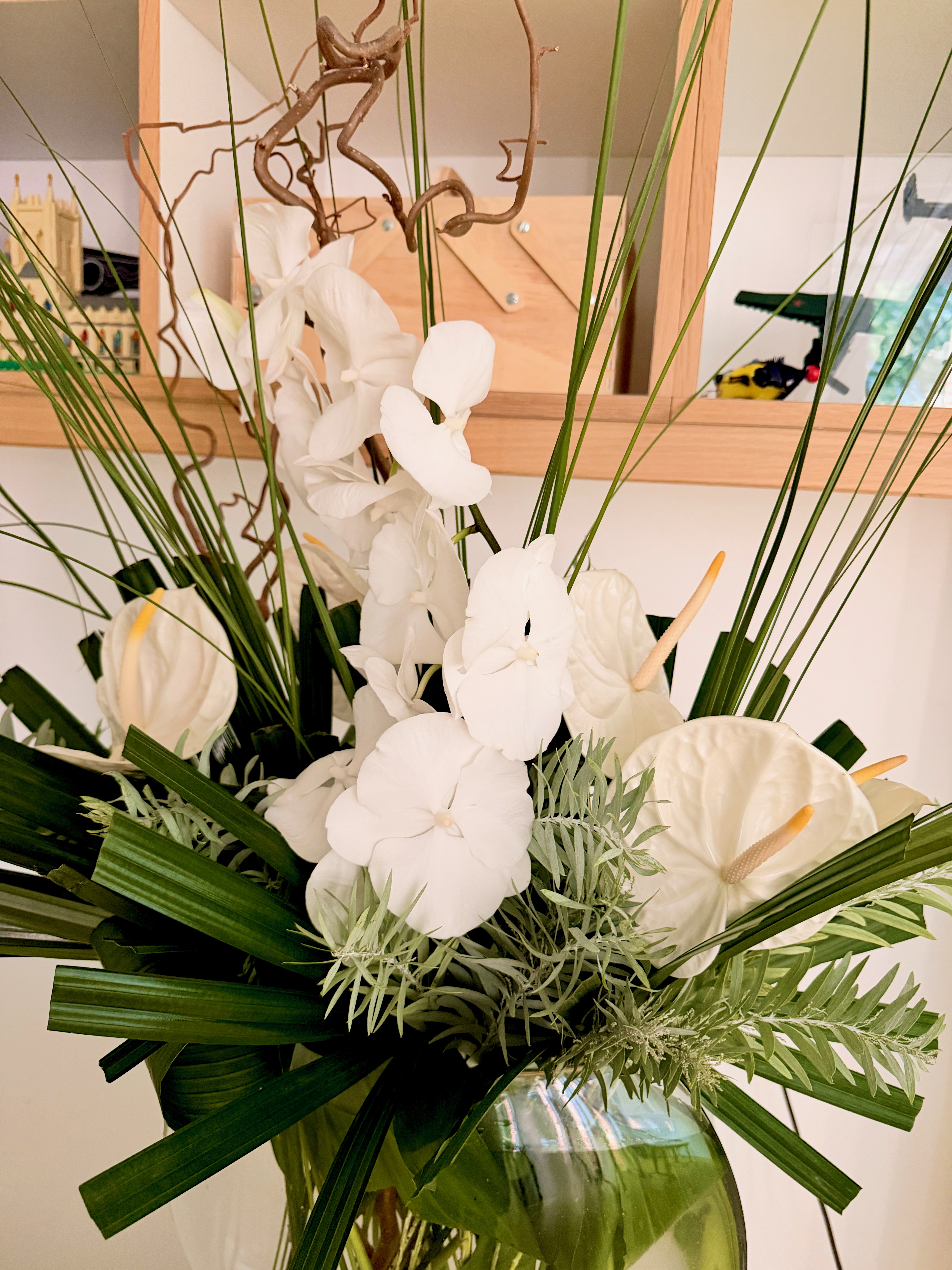 White orchids and anthuriums with folded foliage and tall stems
