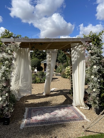 A flower-covered garden ceremony entrance designed by Michael Pooley