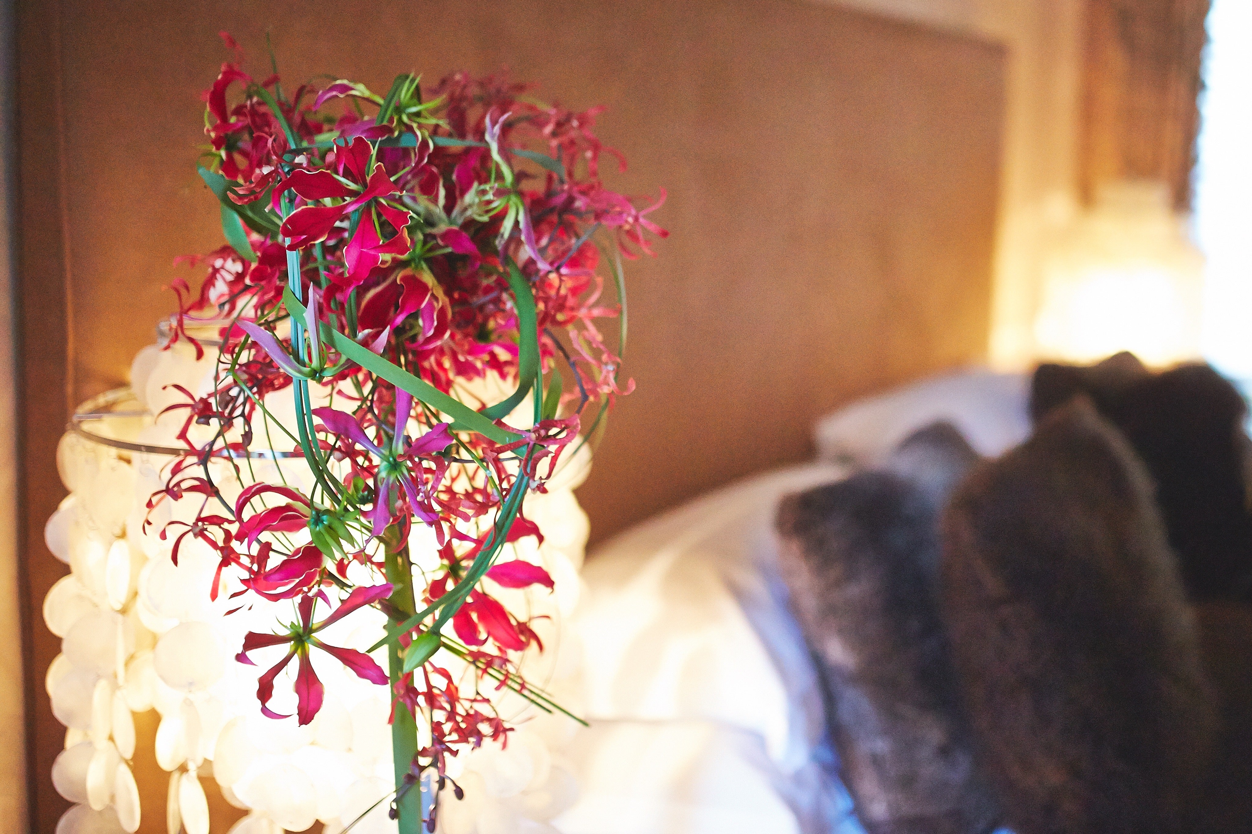 An intricate red Gloriosa bridal bouquet with an open, cascading silhouette